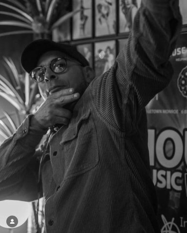 DJ raising hand to hype the crowd during a high-energy set.